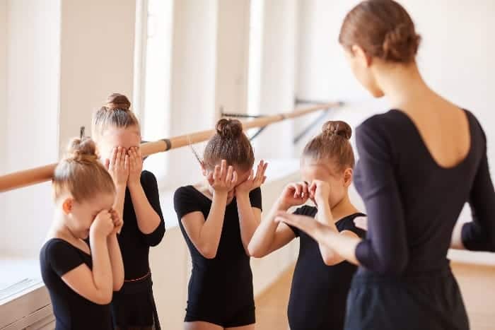 Young dancers with teacher crying | What are the Responsibilities of a Youth Sports Coach?