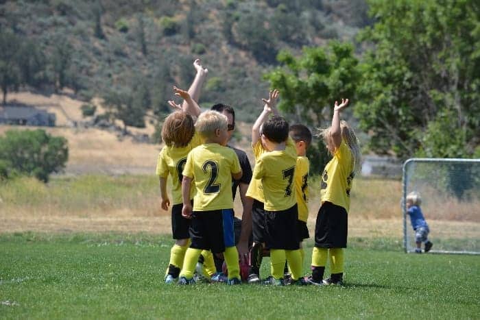 Young soccer team in a group| What are the Responsibilities of a Youth Sports Coach?