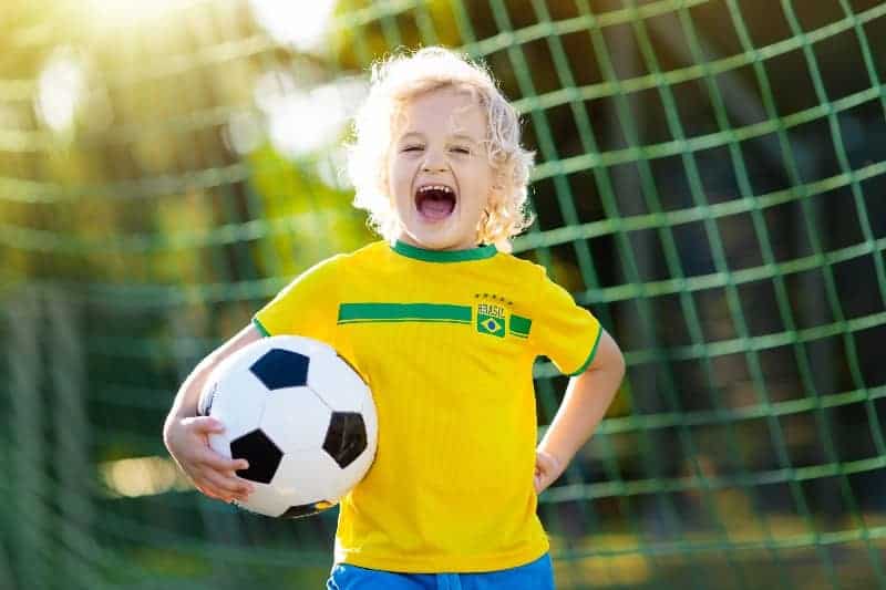 5 year old soccer player holding soccer ball smiling | How to Coach Soccer to 5-Year-Olds