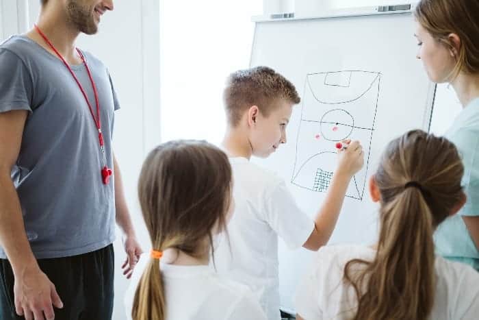Youth boy drawing on white board | How Beginner Youth Sports Coaches Can Earn Player Respect