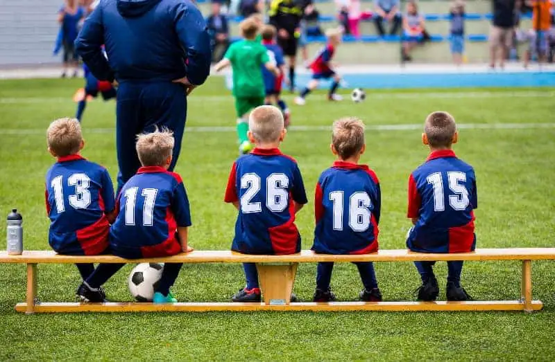 Kids sitting on the bench | Should There Be Equal Playing Time in Youth Sports?