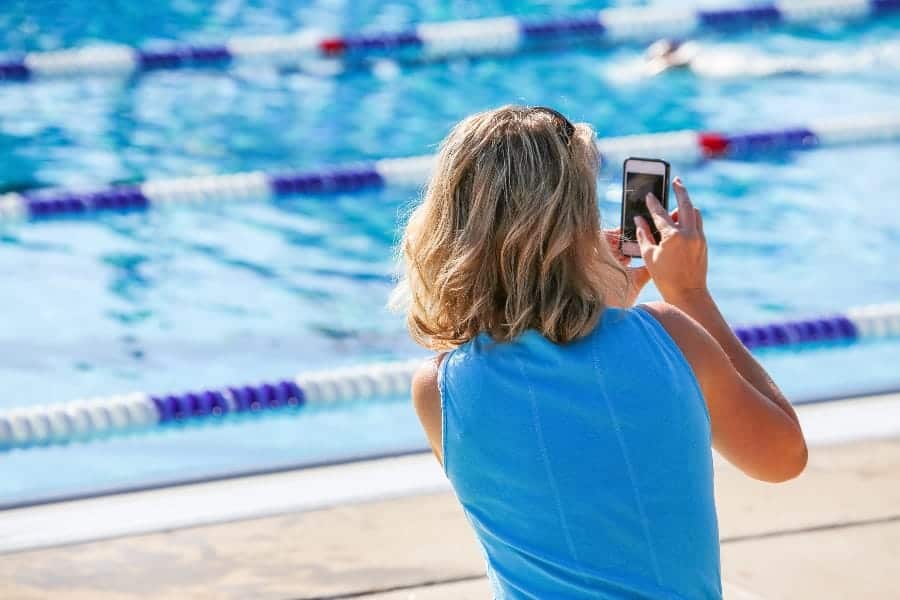 Swimming team mom taking pictures | What Does A Team Parent Do? 17 Ways To Stop A Coaches Headache