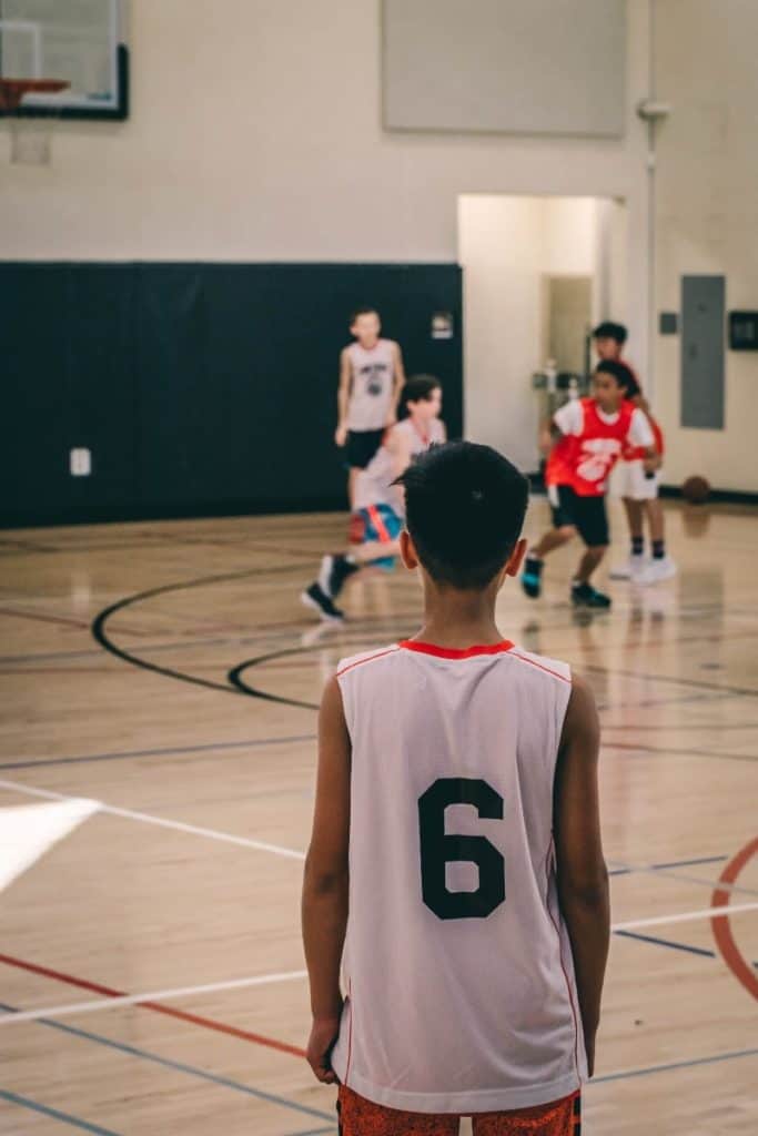 Young player watching basketball | How Many Players Should Be On A Youth Basketball Team?