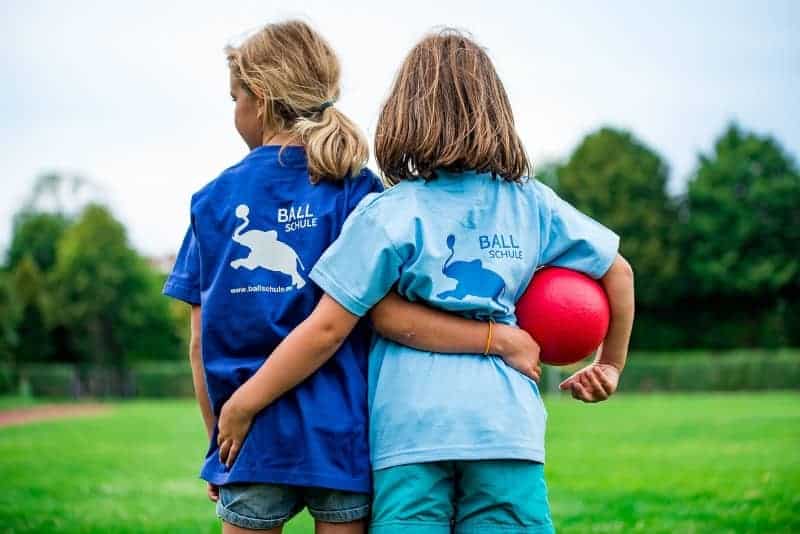 Two girls linking arms | 5 Ways Coaches Can Motivate and Excite Young Female Athletes
