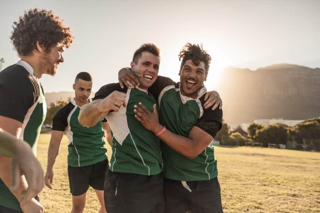 Male athletes smiling | The Complete Coaches Guide to Building Team Culture In Sport
