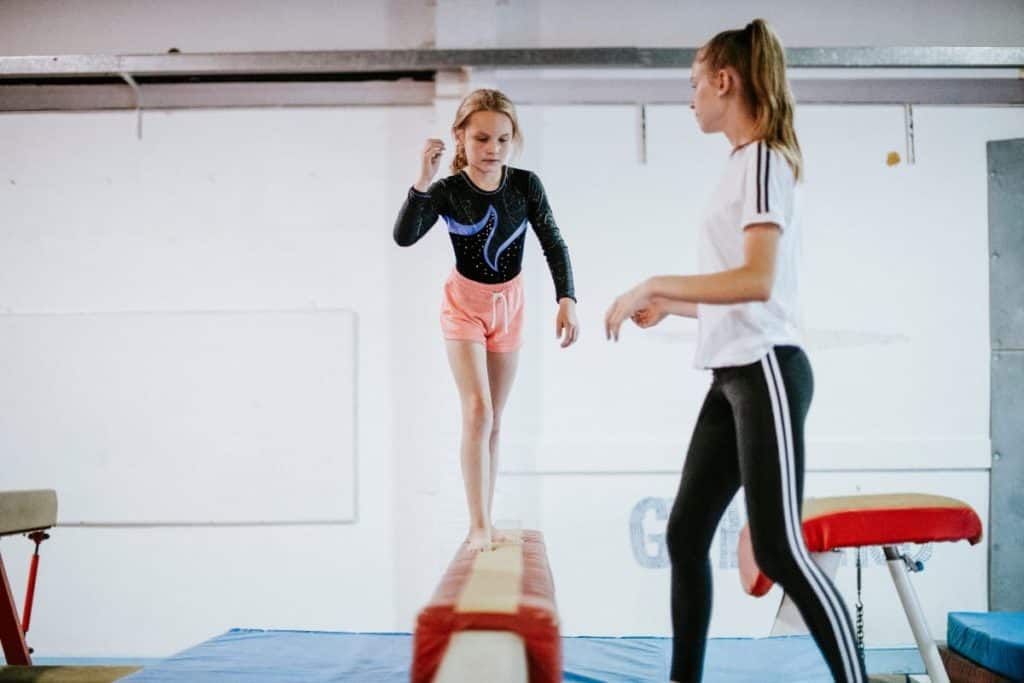 Gymnastics coach with student | Top 10 Tips for Beginner Gymnastics Coaches