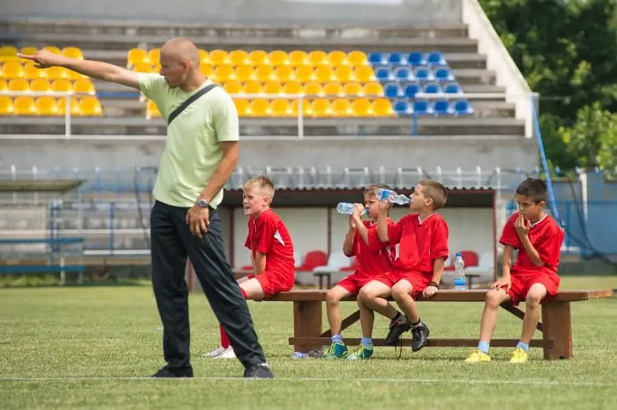 coach pointing with players on the bench | Should There Be Equal Playing Time in Youth Sports?